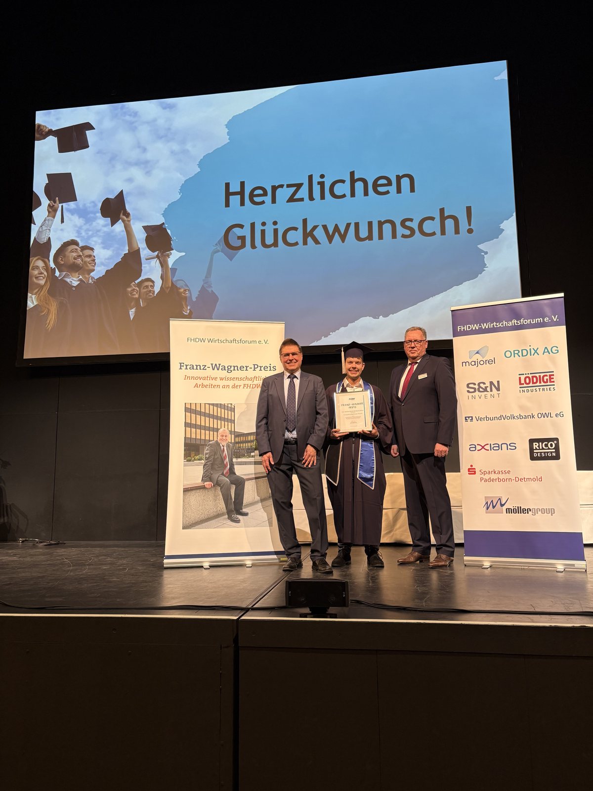 Markus Schulz mit Urkunde bei der Verleihung des Franz-Wagner-Preises auf der Bühne