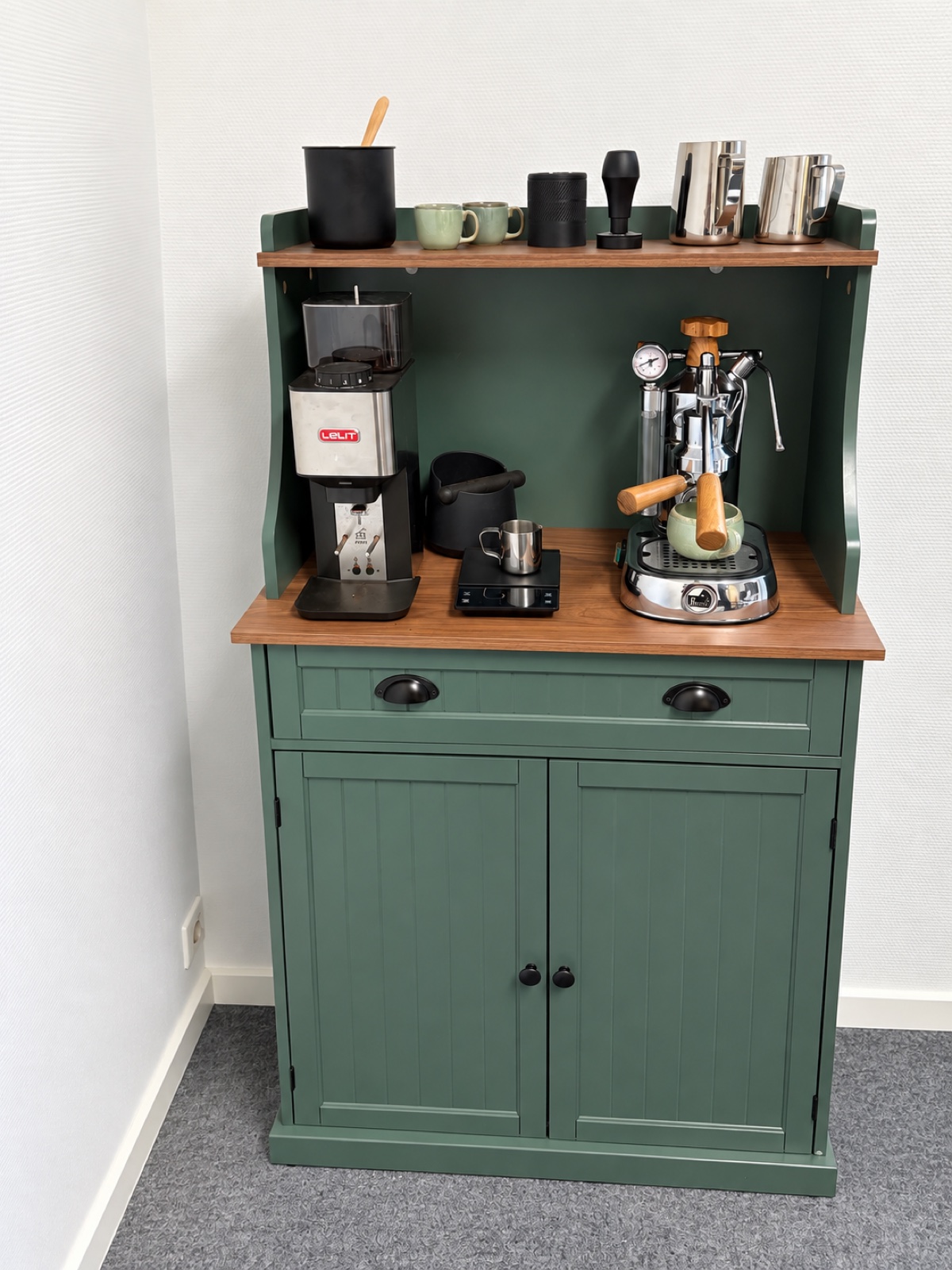 Gebrauchte La-Pavoni-Espressomaschine mit Kaffeemühle und grünen Tassen direkt neben Markus’ Schreibtisch